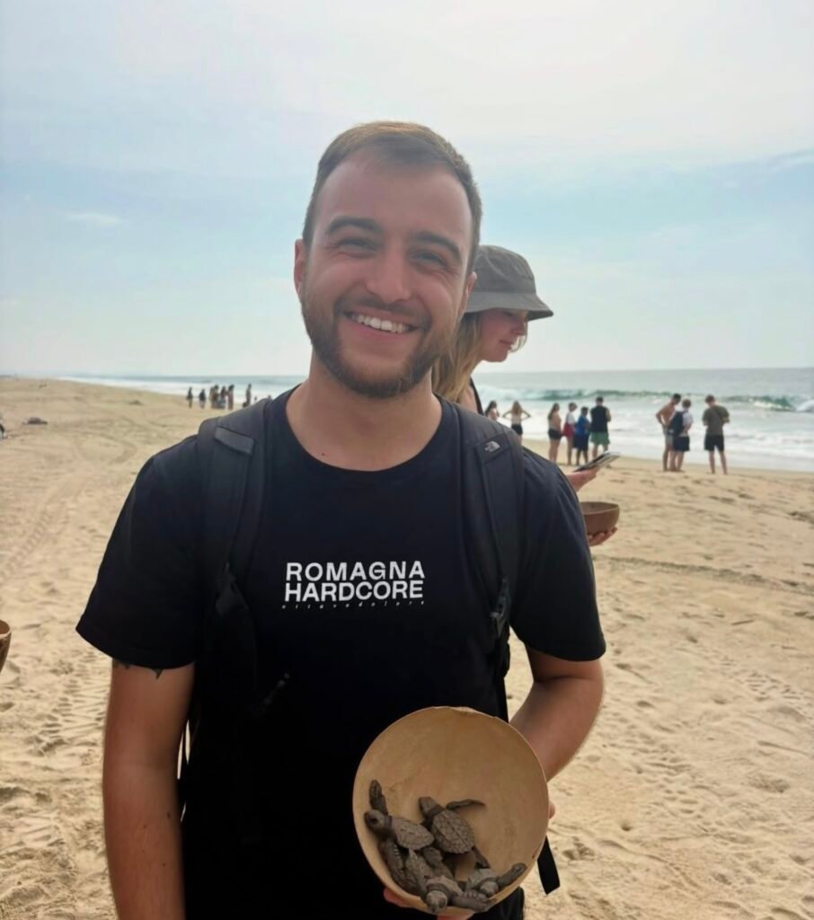 Visitante participando en actividad de liberación de tortugas en Escobilla.